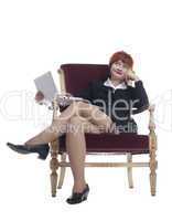 Red young woman in sexy business suit at old-fashion chair with laptop
