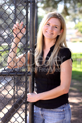 Blond Woman Standing by a Gate