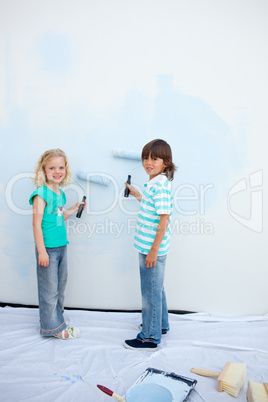 Cute siblings painting a wall