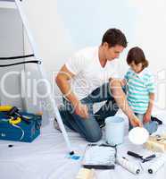 Father and his son painting in their new house