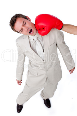 Attractive businessman being hit with a boxing glove