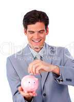 Assertive businessman saving money in a piggy-bank
