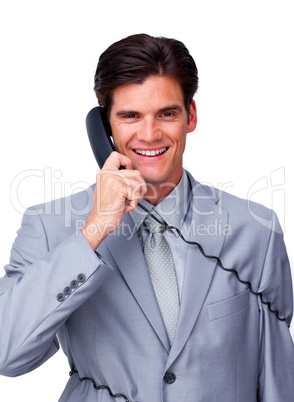 Smiling male executive tangle up in phone wires