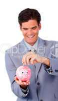 Smiling businessman saving money in a piggy-bank