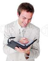 Smiling businessman making notes on his diary