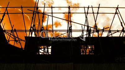 Amber sky floating past derelict building scaffolding