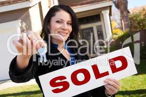 Hispanic Woman Holding Keys and Sold Sign In Front of House