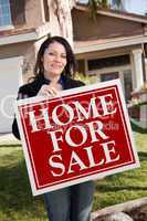 Hispanic Woman Holding Real Estate Sign In Front of House