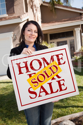 Woman Holding Sold Real Estate Sign In Front of House