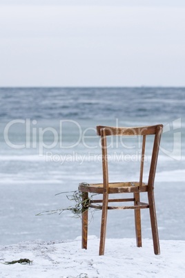 Chair washed ashore and facing the ocean