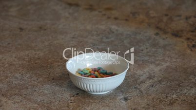 Cereal loops into bowl slow motion