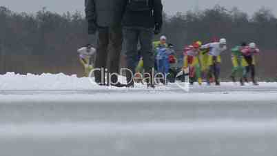 Zwei Personen schauen sich  einen Eislaufwettkampf an