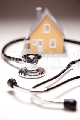 Stethoscope and Model House on Gradated Background