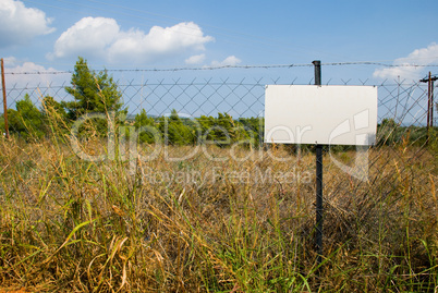 Blank white sign on a chain link fence