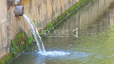 HD Water flowing from the pipe into town river