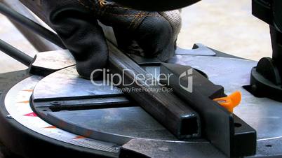HD Metal cutting saw slicing through a steel section, closeup