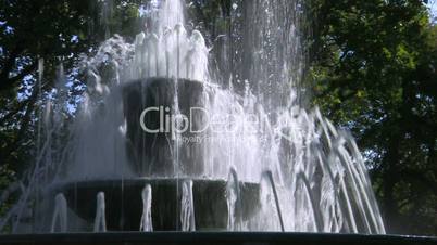 HD Fountain in park, green trees background