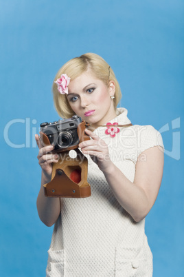 Blond girl look at retro camera