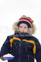 child with shovel look up in winter background