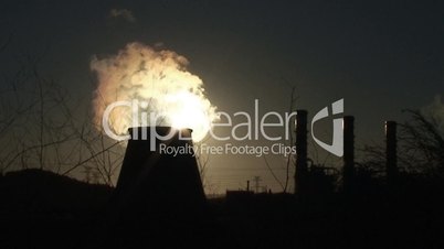 Smokestacks of power plant against sun