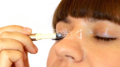 Young woman doing eye make up