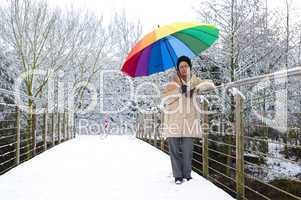 Frau mit Schirm auf einer Brücke
