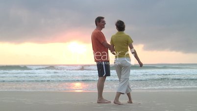 Paar geht und tanzt am Strand