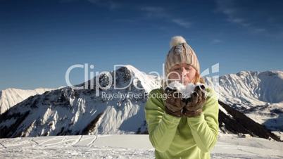 woman blowing on snow