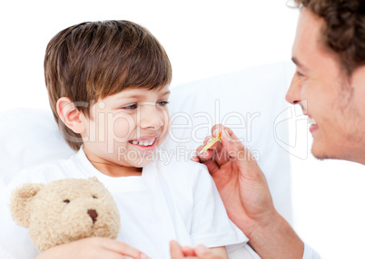 Enthusiastic doctor taking little boy's temperature