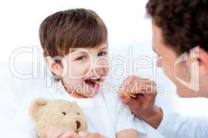 Young doctor taking little boy's temperature