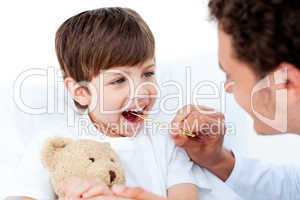 Positive doctor taking little boy's temperature