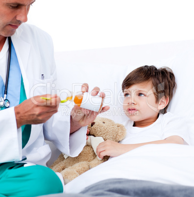 Adorable little boy taking cough medicine