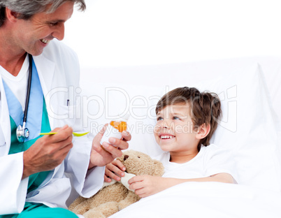 Smiling little boy taking cough medicine