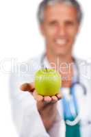 Smiling doctor presenting a green apple