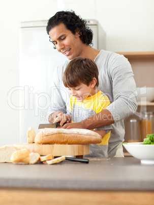 father helping his son cut some bread