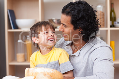 child eating bread with his father