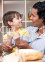 little boy and his father cutting bread