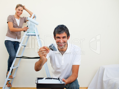 Smiling couple painting a wall