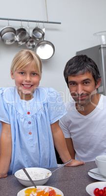 Blond little girl and her father having breakfast