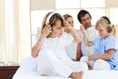 Jolly siblings listening music with headphones