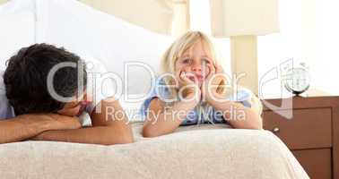 Little girl lying on bed with her father