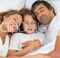 Little boy and his parents sleeping together