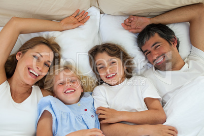 Smiling family having fun in the bedroom