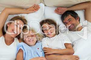 Smiling family having fun in the bedroom
