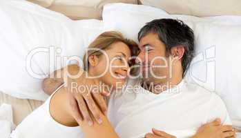 Affectionate couple hugging lying in bed