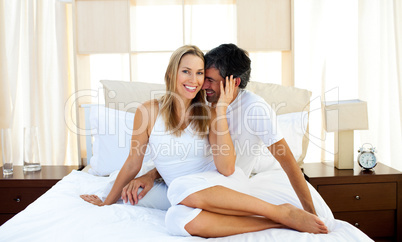 Caring lovers embracing on bed
