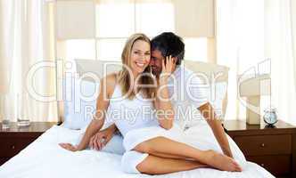 Caring lovers embracing on bed