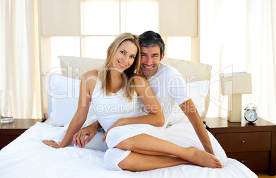 Affectionate lovers embracing on bed