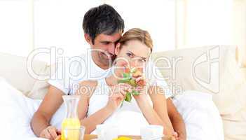 Caucasian couple having breakfast lying in the bed