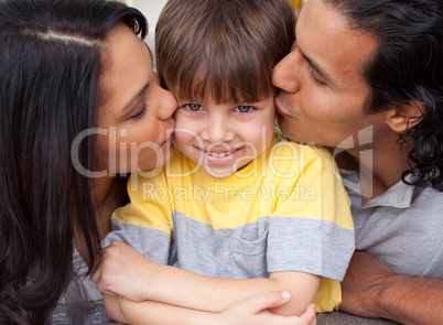 parents kissing their son